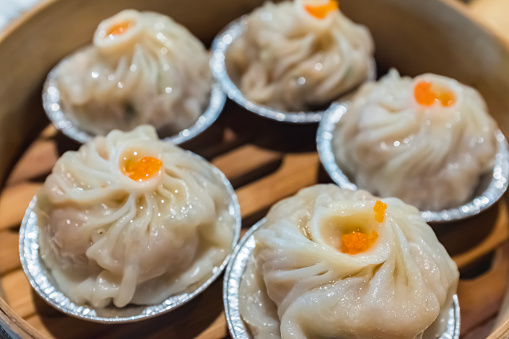 Close up steamed buns stuffed with crab-meat in steamer. A Tray of Chinese Dumplings with Soup Inside
