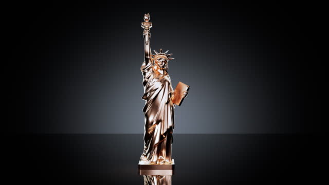 Statue of liberty figurine covering in golden color on a black background