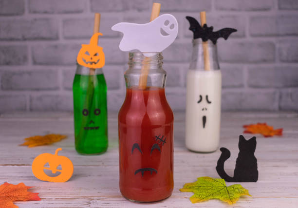 istock Drink idea for Halloween party. Drinks in bottles with monster faces. Jack-o-lantern face on glass. 1432761483
