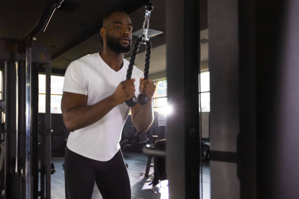 istock Handsome african man doing heavy weight exercise for triceps in the gym. 1432766875