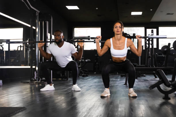 attraktive sportler trainieren mit langhanteln im fitnessstudio. - 16085 stock-fotos und bilder