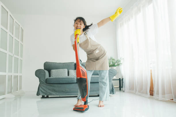 istock Young woman having fun while cleaning home. 1432769745
