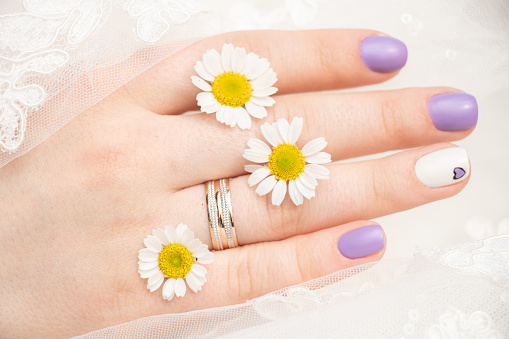 hands of the bride with a wedding ring and daisies in her fingers, wedding day