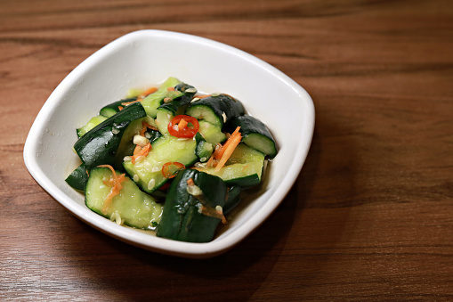 Cold pickled cucumber with red chili in a white bowl, Taiwanese appetizer food.