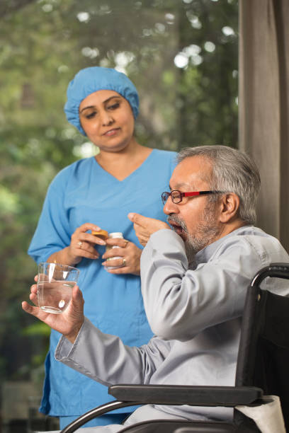 istock Female nurse giving medication to old man 1432771895