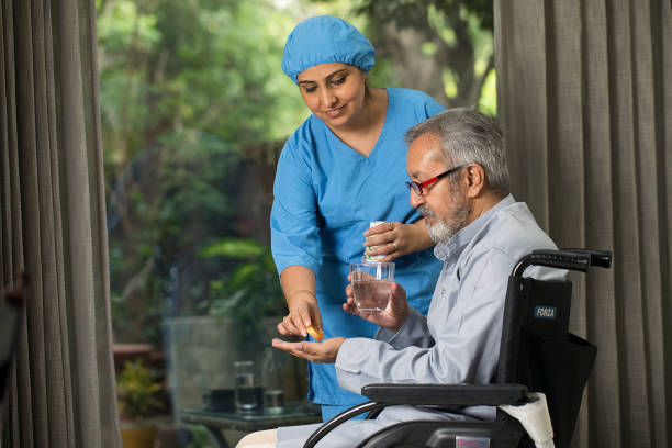 Female nurse giving medication to old man
