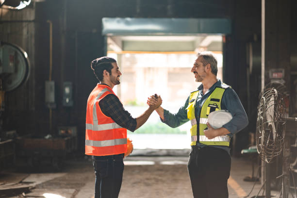 istock Caucasian factory engineer talking and shaking hands on business cooperation agreement. Successful hand shaking after good deal, workers handshaking each other at heavy industrial production line. 1432771958
