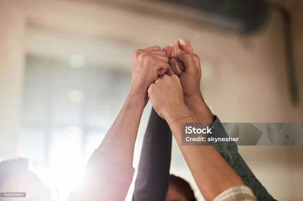 Raise your fists in unity! Close up of group of unrecognizable people raising their fists in success. Human Rights Stock Photo