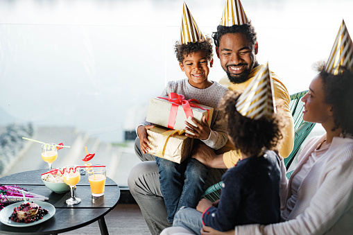 Happy African American family having fun during Birthday celebration on a terrace.