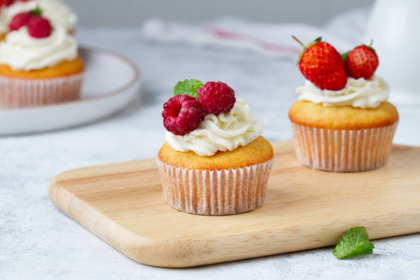 istock Cupcake with raspberries on a wooden board 1432776518