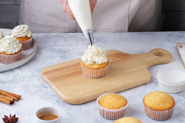 istock A pastry bag applies cream to a cupcake 1432776665
