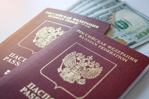 Two international Russian passports and a stack of American dollars. Travel concept.
