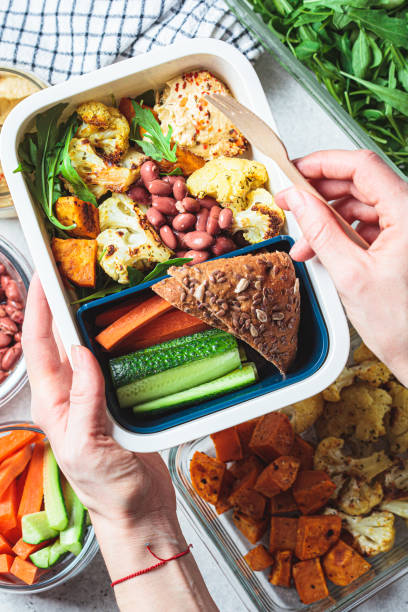 istock Cooking vegan lunch box flat lay. Hummus, beans, baked vegetables, green salad, rye bread and vegetable sticks in a plastic container. 1432777085