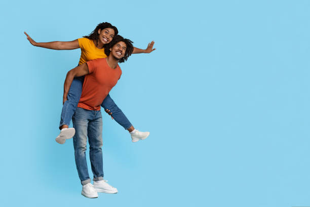istock Cheerful black guy piggybacking his happy girlfriend 1432778197