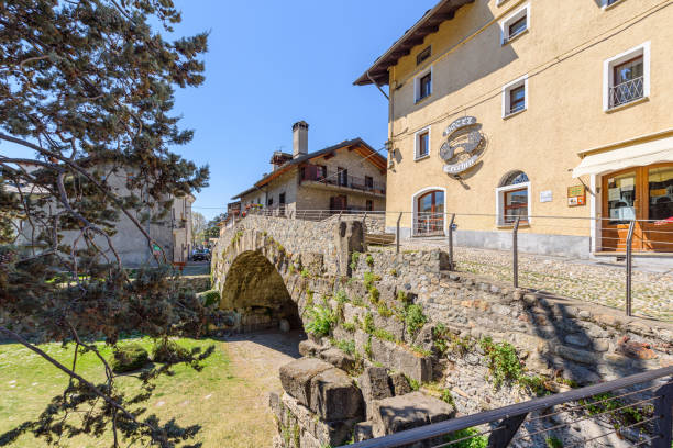 aosta, itália. vista da ponte romana entre as casas do centro da cidade. - valle daosta - fotografias e filmes do acervo