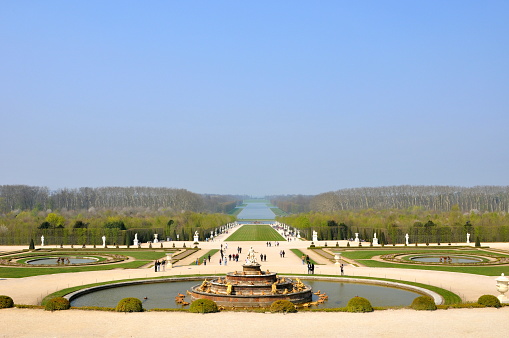 Paris, France- April 10, 2010: Paris is the center of French economy, politics and cultures and the top travel destinations in the globe.  It attracts the tourists all over the world.  Here is the garden and canal out of Chateau de Versailles.