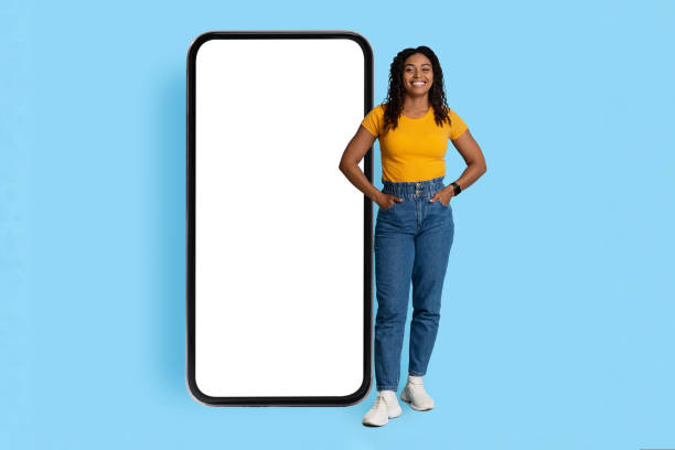 istock Pretty african american lady posing with smartphone with blank screen 1432784597
