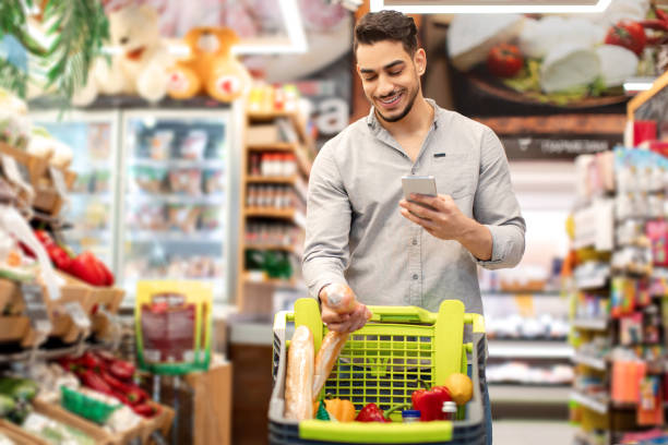istock Middle Eastern Male Doing Grocery Shopping Using Cellphone In Supermarket 1432786717