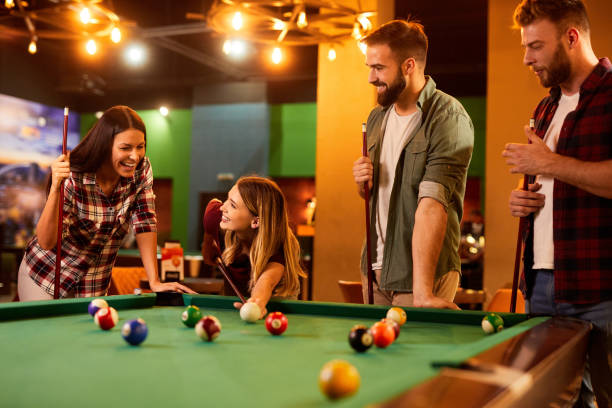 istock Group of friends having fun while playing pool in a local pool hall 1432786756