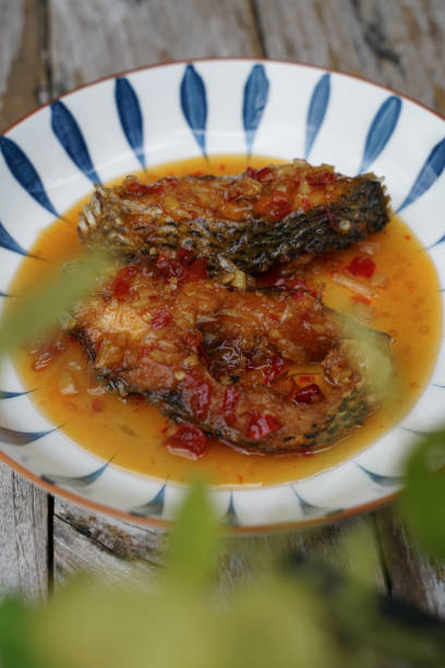 istock Fried fish with chilli in a ceramic plate on an old wooden floor. 1432786849