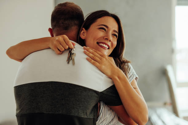istock Happy wife hugging husband and holding keys. 1432786946