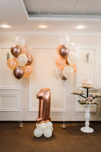 istock Birthday Cake on a background balloons party decor. Delicious reception. Celebration concept. Trendy autumn decor. Arch decorated with white, brown, and gold balloons. Arch for 1 year and a photo wall 1432788596