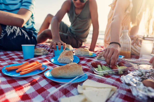 Family having summer picnic breakfast on the beach