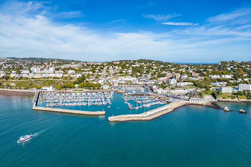 Aerial view of a small passenger ferry leaving Torquay Harbour on a sunny day.