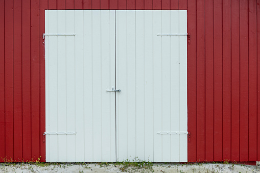 Red door and exterior barn wall - stock photo