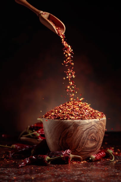 istock Chilli flakes are poured into a wooden dish. 1432798509