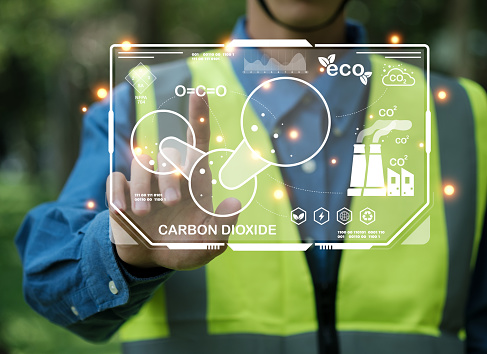 Renewable energy-based green businesses can limit climate change and global warming. Reduce CO2 emission. Environmental engineering touching green CO2 icon and green icon on a green background.