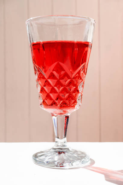 istock Glass of an exquisite red cocktail on a white surface. 1432807346