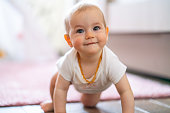 istock Baby girl crawling on the floor at home 1432807347