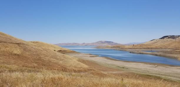 istock Beautiful hills landscape with a lake under a clear blue sky 1432808157