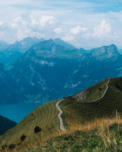istock Vertical high angle view of mountain peaks surrounded by greenery and water 1432808284
