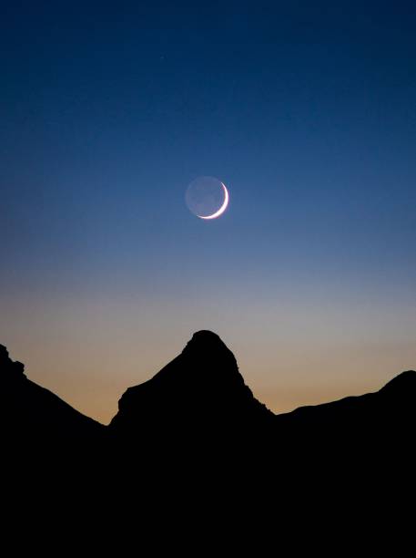 istock Waxing crescent moon over mountain silhouette 1432809647