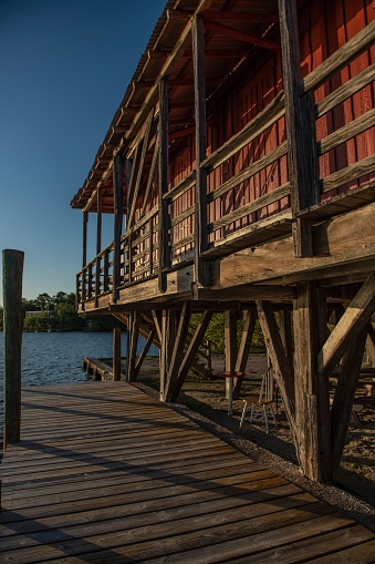 A scenic view of a wooden pier over body of water in Chokoloskee, Florida under blue sky at sunrise