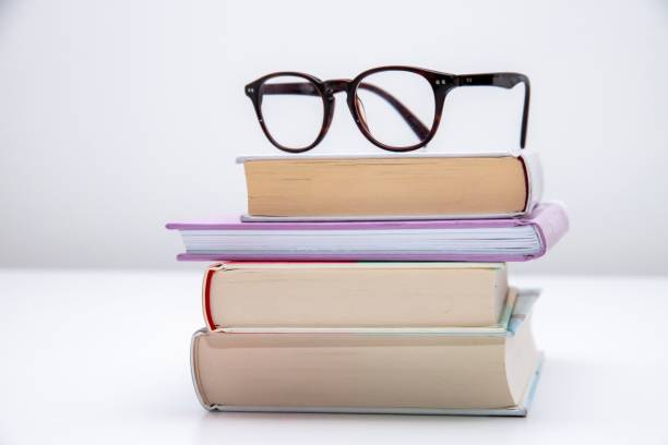 istock Stack of books with optical glasses on top, isolated on a white background 1432812690