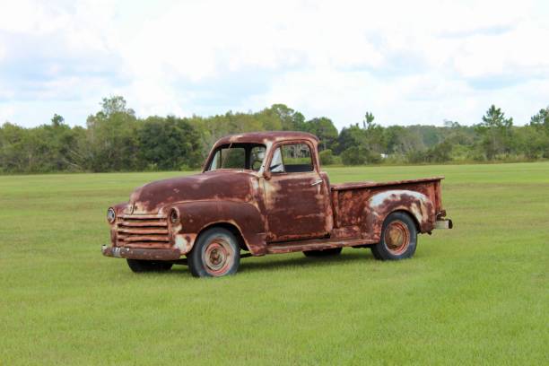 istock Old rusty pickup car in the green field. 1432812937