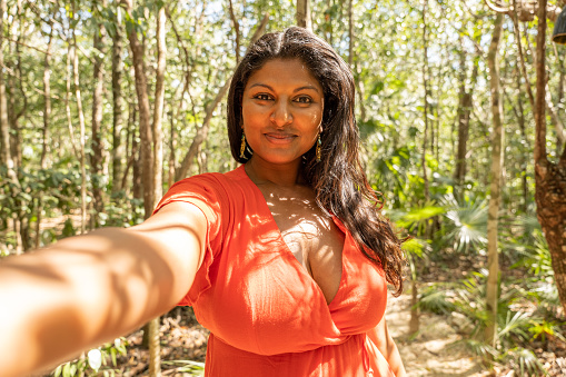 Loneliness in nature, woman poses around lush foliage.
Indian ethnicity beautiful woman walking in tropical rainforest