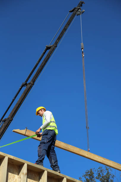 istock Construction worker standing on a wooden house construction site 1432814048