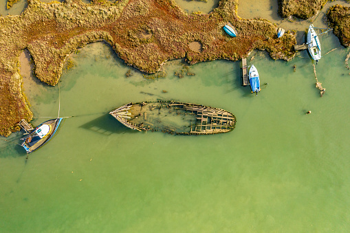 Aerial photo from a drone of shipwreck in a salt marsh in Tollesbury, Essex, UK. This particular marsh is located in the RSPB Old Hall Marshes in the Blackwater Estuary National Nature Reserve.