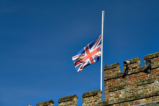 A closeup shot of the flag of the United Kingdom near an ancient building