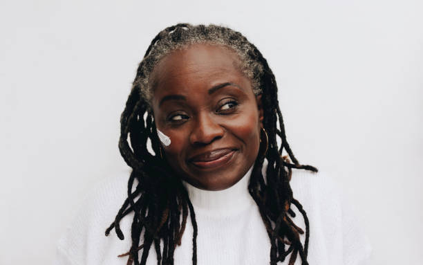 istock Mature woman with dreadlocks applying a beauty cream on her face 1432816995