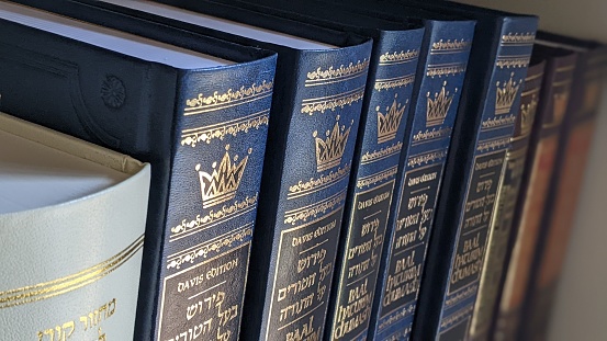 A closeup shot of Hebrew Bible books on the bookshelf