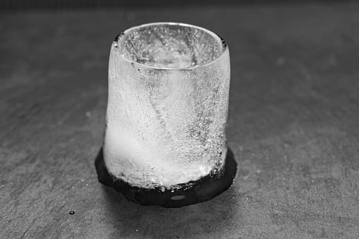 the process of melting an ice cube. black-and-white. turning ice into water.