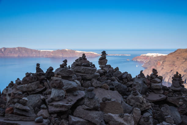 Rock balancing, with caldera landscape in Santorini island, Greece stock photo