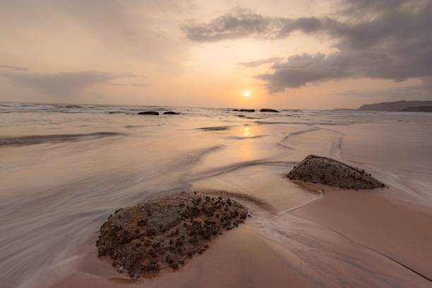 istock Beautiful view of a sandy beach with waves and stones 1432820116