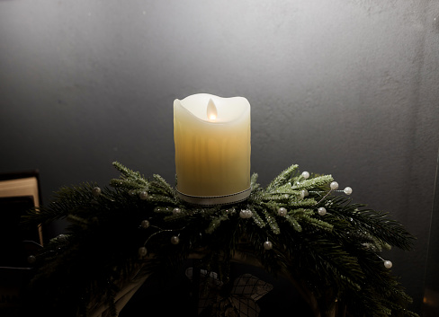 Traditional outdoor decoration in Finland in winter. The block of ice is usually made by leaving a bucket of water to stay outside overnight in cold temperature. The result is a hollow block of ice. Blurred fairy lights on the background.