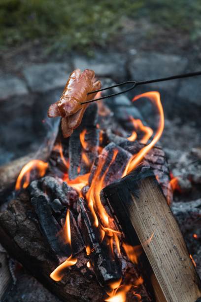 istock Vertical shot of a sausage on a spit being roasted on a fire 1432821352